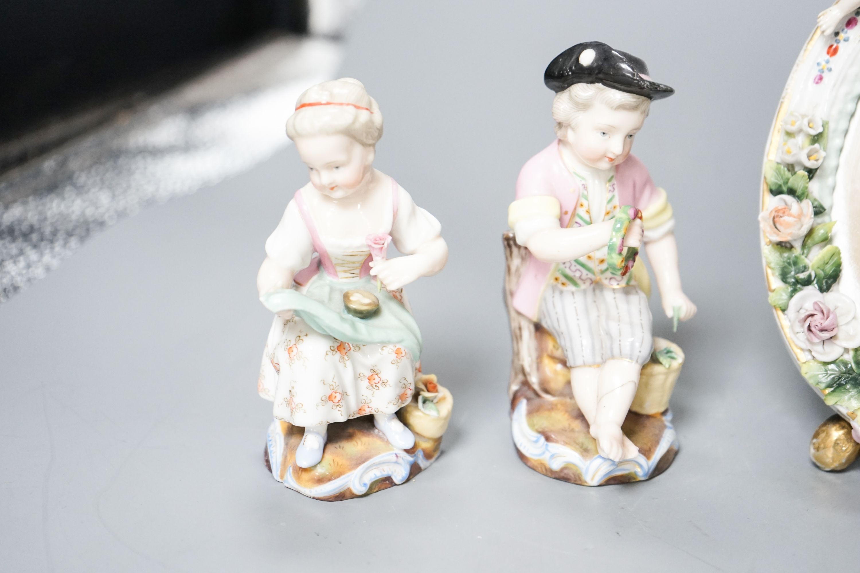 A pair of Meissen groups holding chickens, 10.5cm, a pair of Sitzendorph figures and a Sitzendorf mirror 18cm